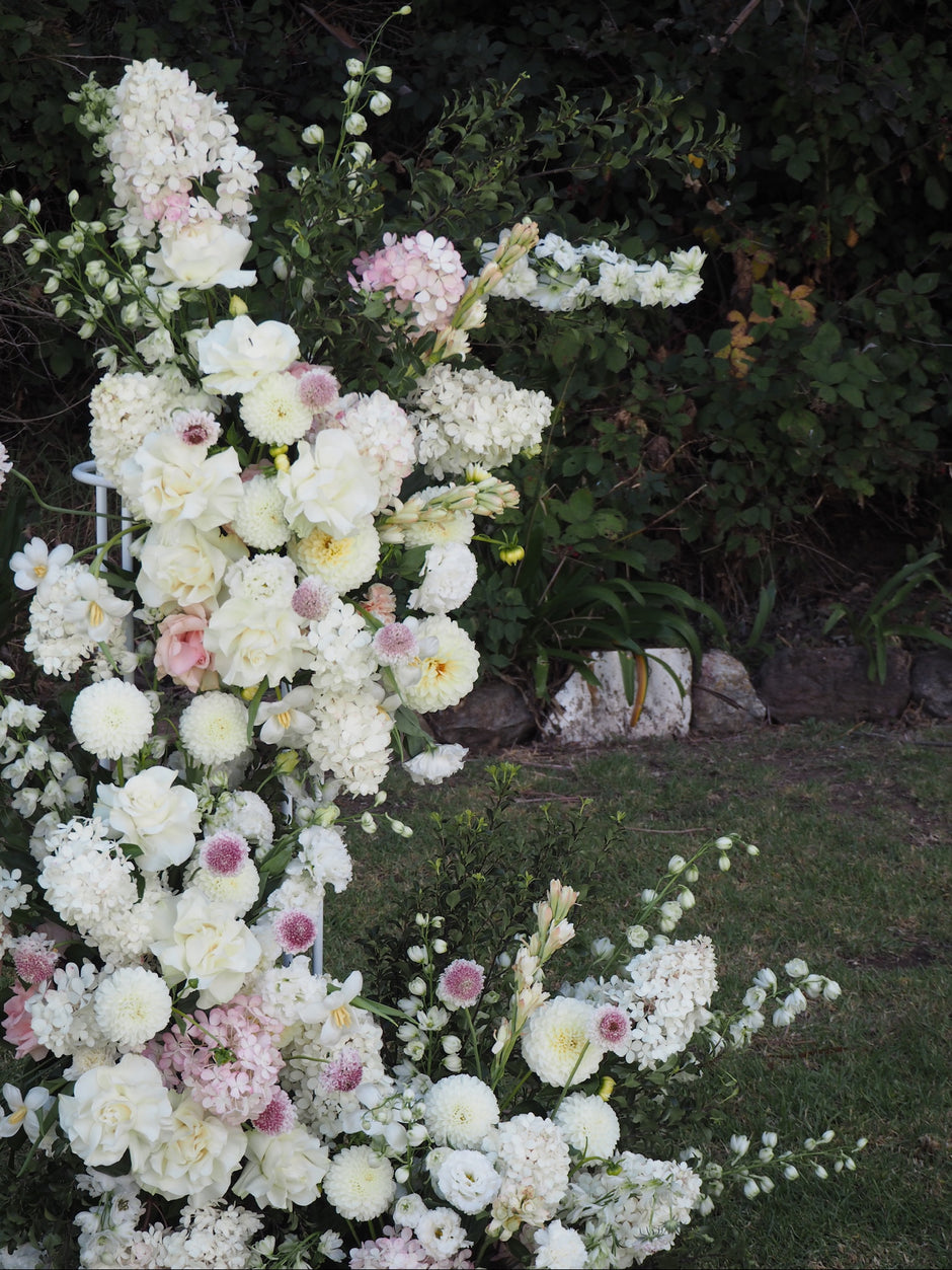 Floral arrangement with white and pink flowers on a grassy background