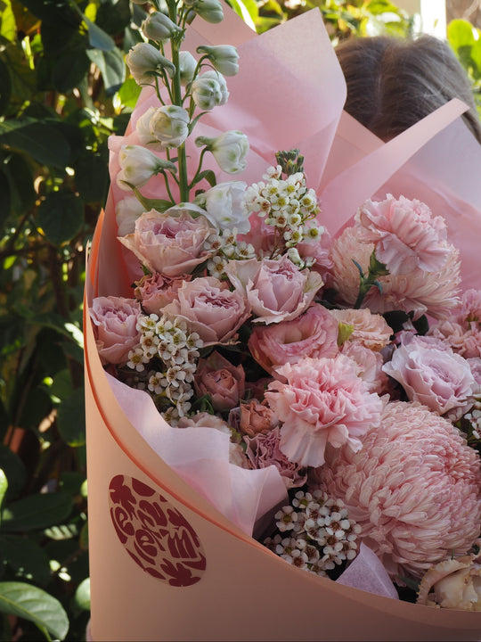 Bouquet of pink flowers wrapped in pink paper.