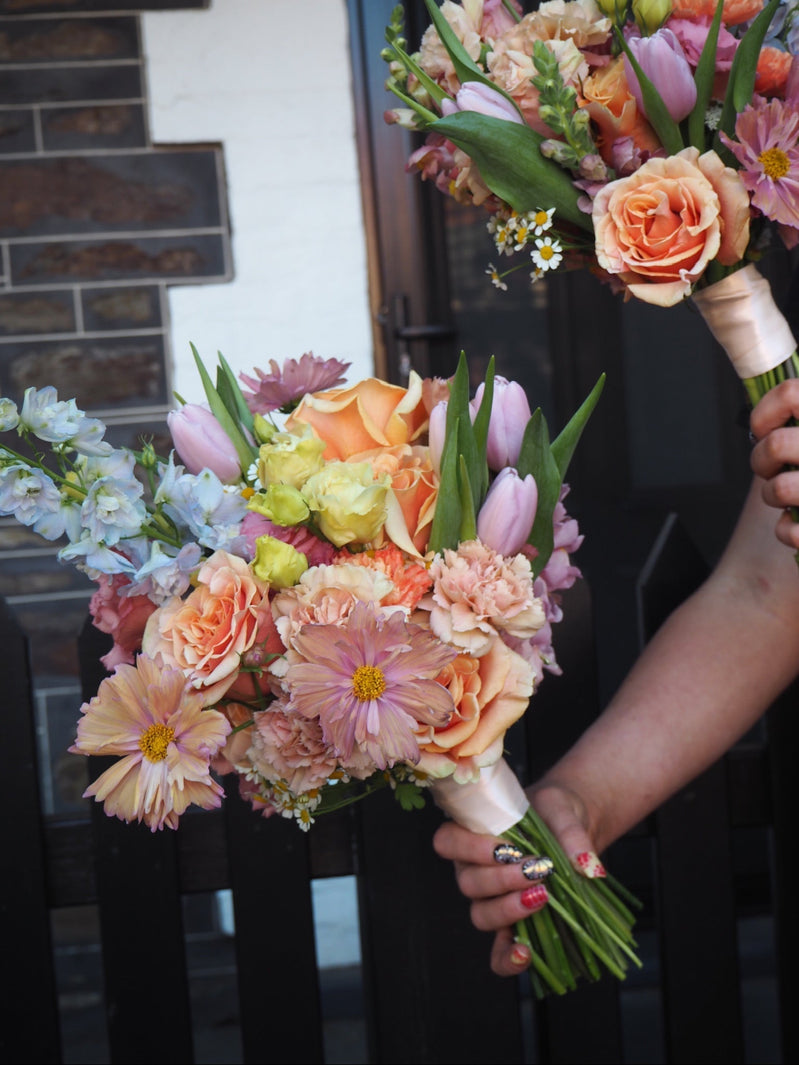 bridal bouquet of colourful seasonal blooms, in peach, lilac and blue tones