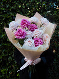 Load image into Gallery viewer, Person holding a bouquet of one dozen faux, real-touch roses in shades of pink.
