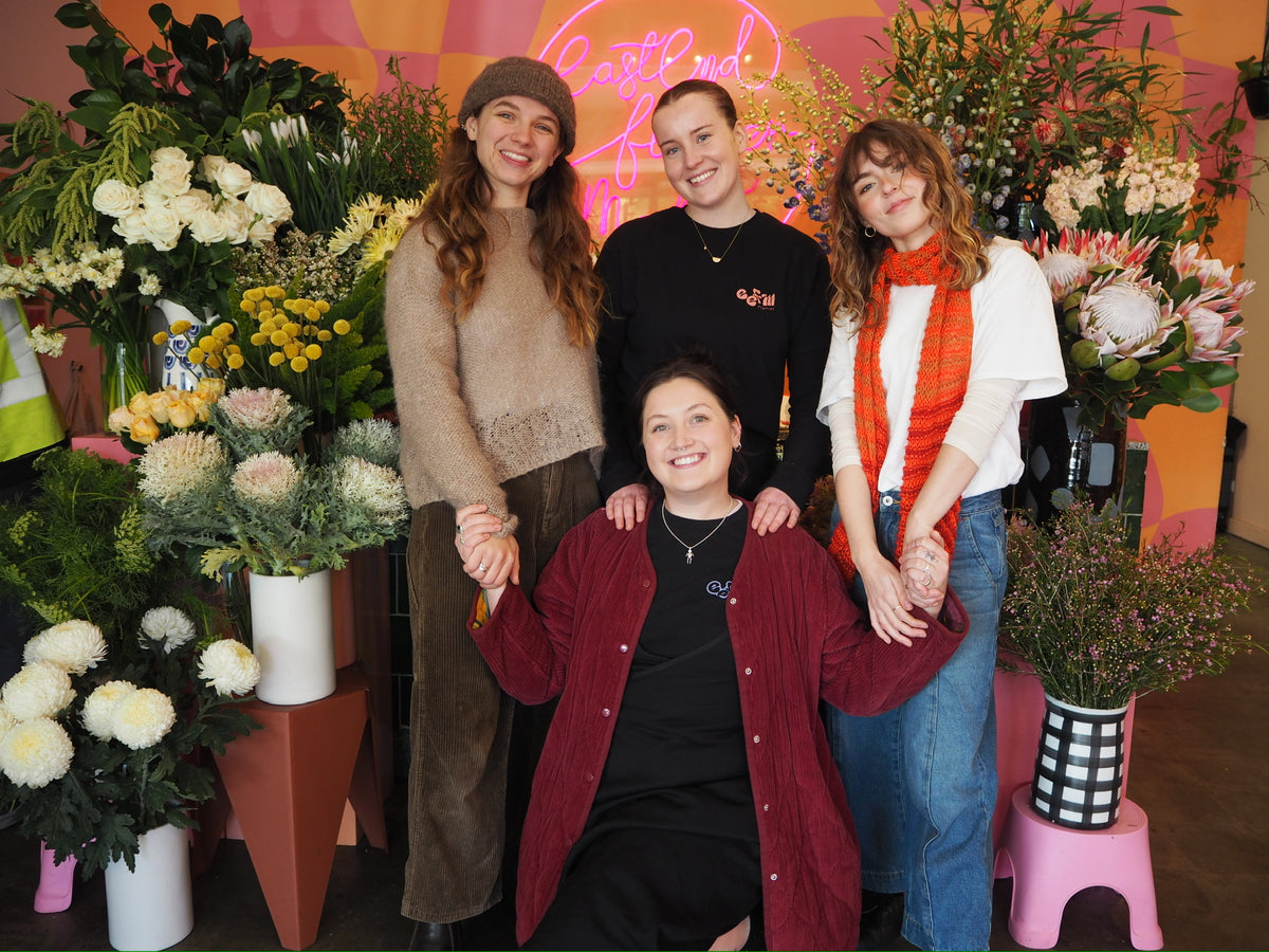 4 women in front of a display of flowers
