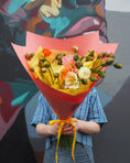 Load image into Gallery viewer, Person holding a bouquet of poppies in front of a colourful mural.
