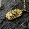 Load image into Gallery viewer, Gold Virgo zodiac pendant on a dark stone surface
