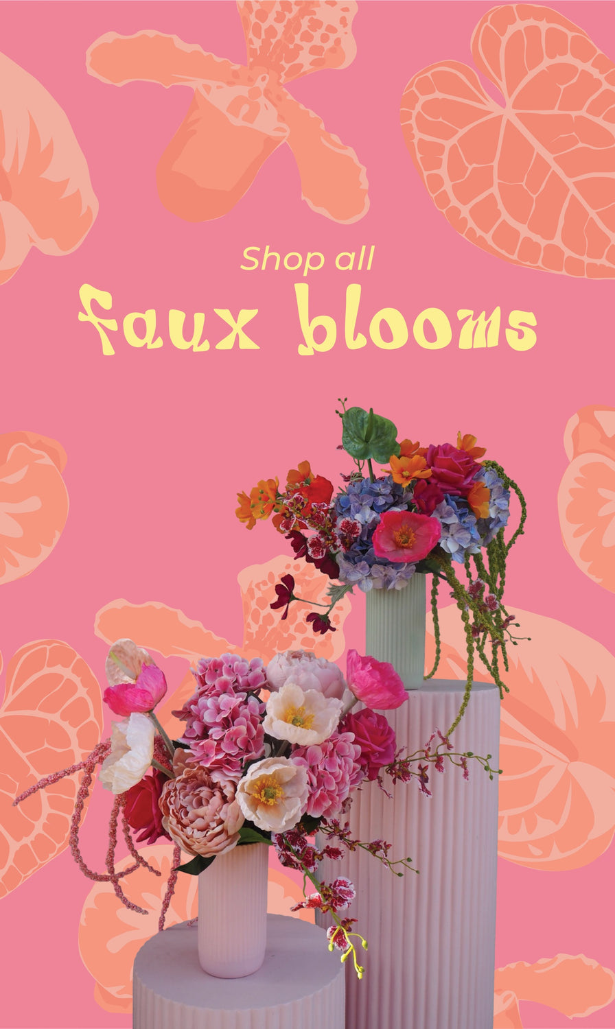 Colorful faux flowers in vases on a pink background with floral patterns.